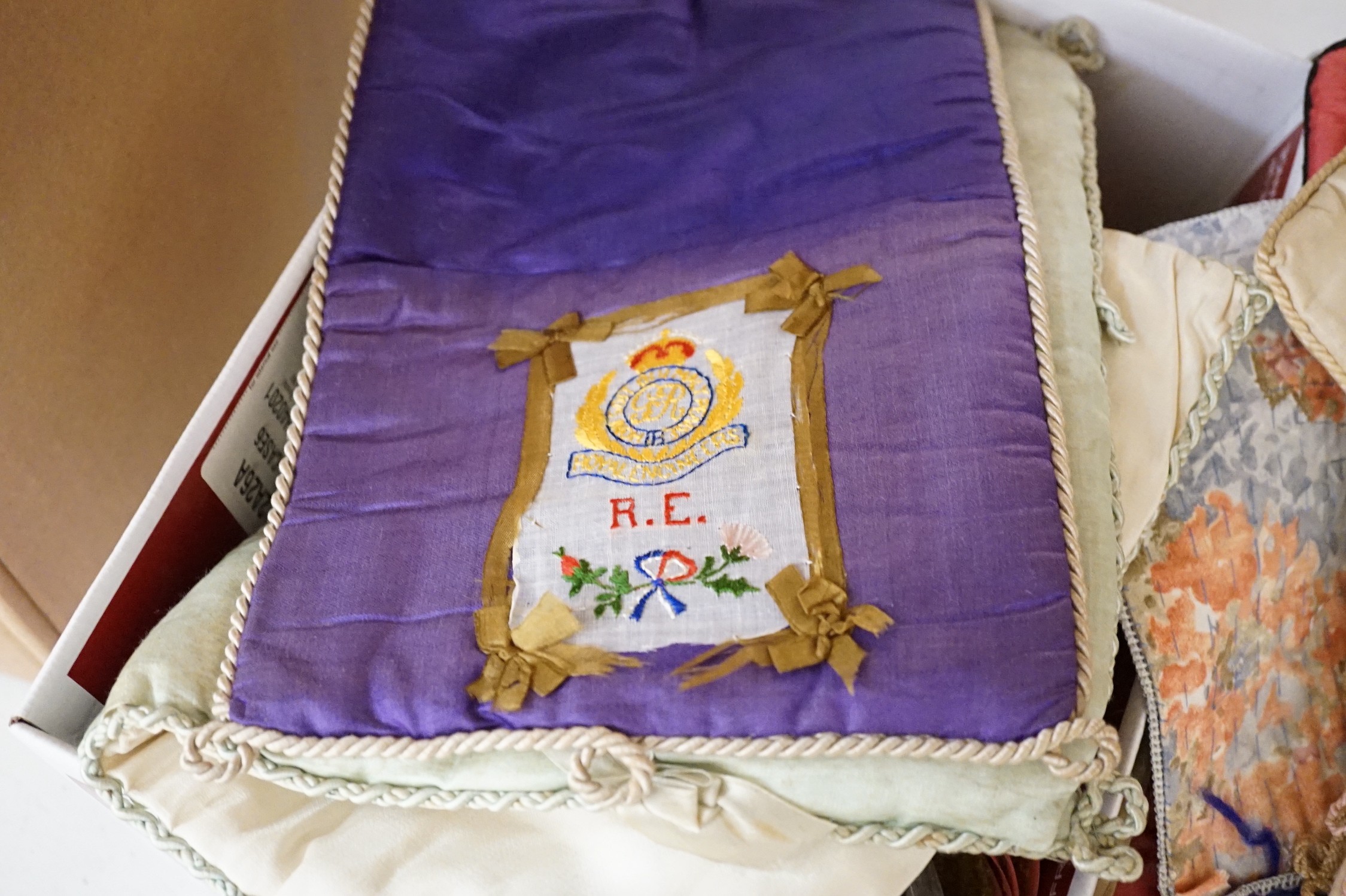 A large collection of mixed European textiles including ribbon worked pyjama cases, Indian painted textiles, a sample book of braidings etc